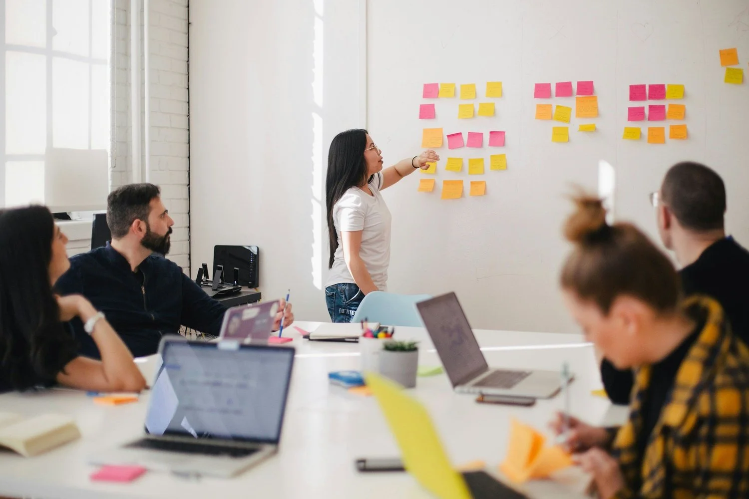 A woman mapping a business process with sticky notes